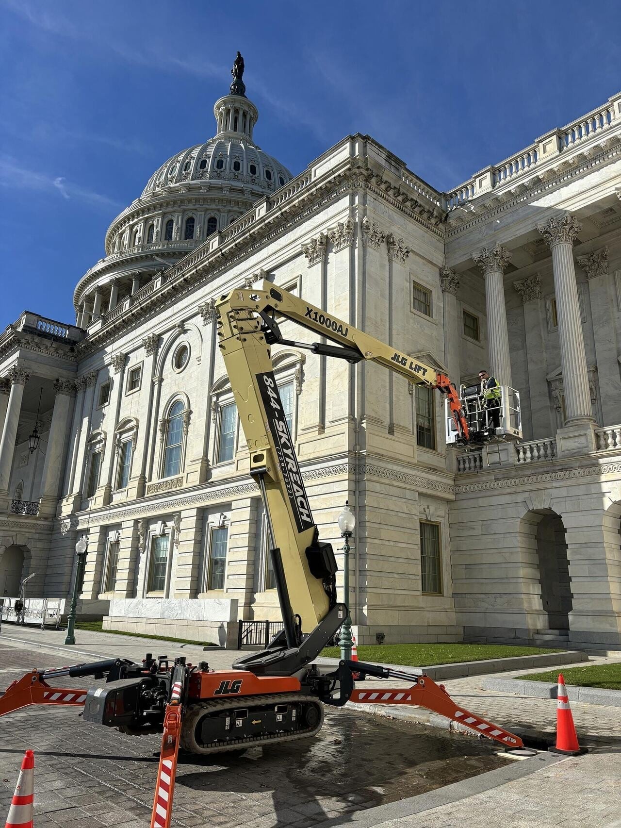Skyreach JLG X1000AJ boom lift with technicians working on stonework at the U.S. Capitol building